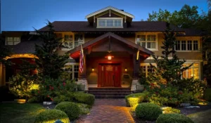 Custom lighting design illuminating home exterior pathway trees and entry creating depth visibility and warm curb appeal at night.