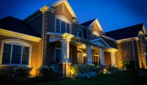 Landscape lighting installation showing illuminated home, garden, and pathways during spring evening with balanced outdoor lighting design.